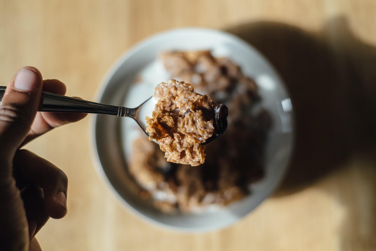 person holding teaspon with cereal